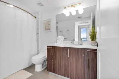 a bathroom with a sink and a toilet and a mirror at Gorgeous 3-Bed Retreat Mins from Bayside and Parking in Miami