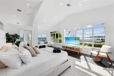 a white living room with a large white couch and windows at Villa Hashmi Luxury 5BD & 5BA Retreat on North Bay Island in Miami Beach