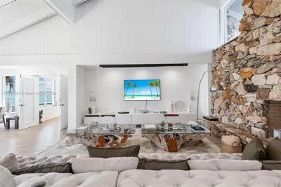 a living room with a couch and a stone wall at Villa Hashmi Luxury 5BD & 5BA Retreat on North Bay Island in Miami Beach