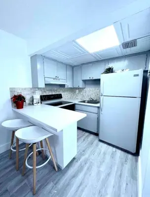 a kitchen with a white refrigerator and a table and chairs at Miami International Airport 1 in Miami