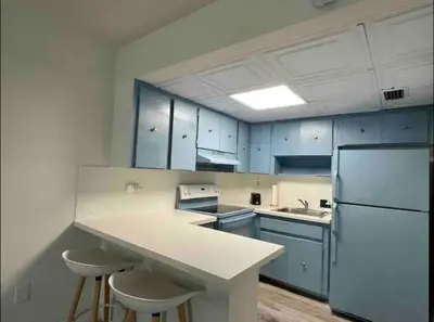 a kitchen with blue cabinets and a white refrigerator at Miami International Airport 1 in Miami