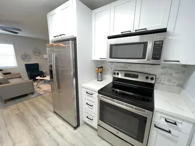 a kitchen with a stainless steel refrigerator and a microwave at Villa Michloe - Steps from Wilton Drive in Fort Lauderdale