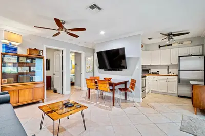 a kitchen and living room with a table and a tv at Wilton Manors 2BR Charm! Walk to the Drive in Fort Lauderdale