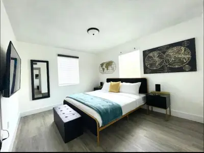 a bedroom with a large bed in a white room at Miami International Airport 2 in Miami