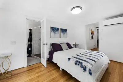 a white bedroom with a bed and a sliding door at Perfect FLL Location with Putting Green in Fort Lauderdale