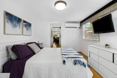 a bedroom with a large bed and a flat screen tv at Perfect FLL Location with Putting Green in Fort Lauderdale