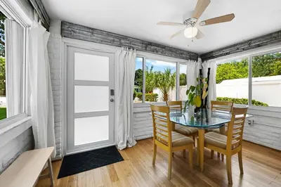 a dining room with a glass table and chairs at Perfect FLL Location with Putting Green in Fort Lauderdale