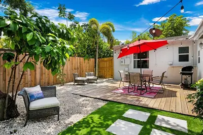 a patio with a table and chairs and an umbrella at Perfect FLL Location with Putting Green in Fort Lauderdale