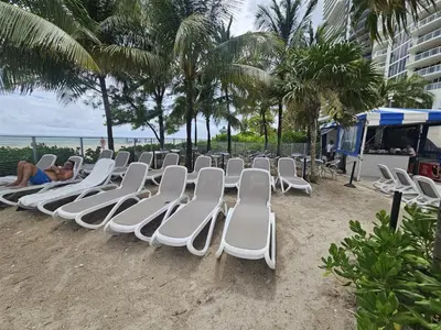 a group of chairs sitting on the beach at Mare-1708 B in Aventura