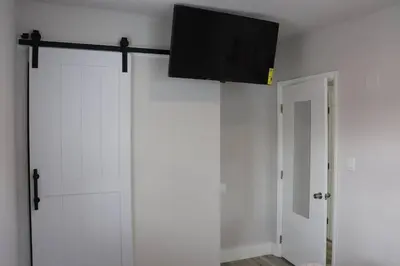 a sliding barn door with a flat screen tv on top at Flamingo Beach House in Dania Beach