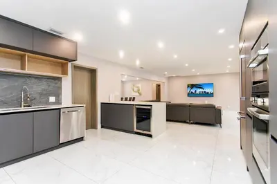 a large kitchen with black cabinets and a tv at Premium Luxury 5BR & 3BA Villa near Hollywood Beach in Hollywood