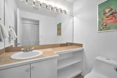 a white bathroom with a sink and a mirror at Center Grove - Lush & Spacious & New - 3 Bedrooms in Miami