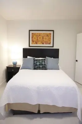 a white bedroom with a white bed with a black headboard at Apt 2 Miami Designer Apartment in the Upper East-Side in Miami