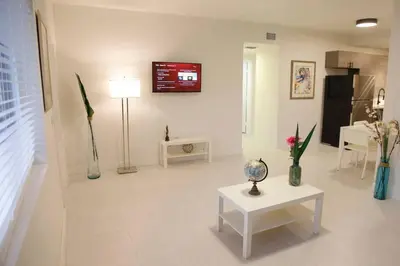 a living room with a table and a tv on the wall at Apt 3 Miami Designer Apartment in the Upper East-Side in Miami