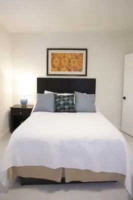 a white bedroom with a white bed with a black headboard at Apt 4 Miami Designer Apartment in the Upper East-Side in Miami