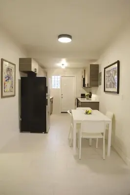 a kitchen with a white table and a black refrigerator at Apt 4 Miami Designer Apartment in the Upper East-Side in Miami