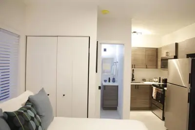 a white kitchen with a white couch and a refrigerator at Apt 6 Miami Designer Studio in the Upper East-Side in Miami