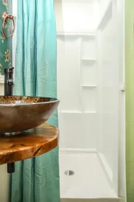 a bathroom with a bowl on a counter next to a shower at Miami Tiny Vintage Cottage in Hialeah