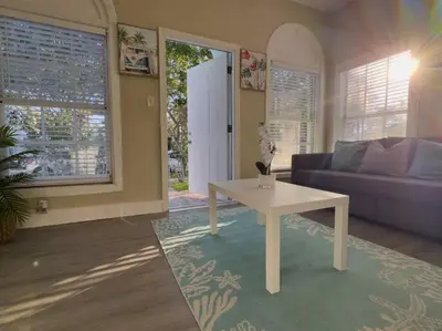 a living room with a table and a couch at Shenandoah Victorian Suite with TV's in every room in Miami