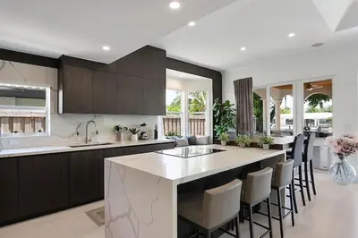 a kitchen with a large island with bar chairs at Infinity Luxury Waterfront Infinity Pool and Hot Tub SLEEPS 8 in Fort Lauderdale
