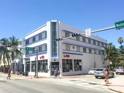 a white building on a street corner with people crossing the street at Best Location SOBE Top Floor 2 min to beach & fun in Miami Beach
