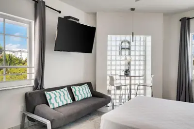 a living room with a couch and a tv at Best Location SOBE Top Floor 2 min to beach & fun in Miami Beach