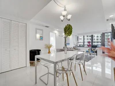 a white dining room with a white table and chairs at Amazing Ocean View Condo Beach Service 1111 in Miami Beach