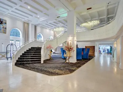 a lobby with a staircase and blue chairs at Spacious Ocean View Condo Beach Service 803 in Miami Beach