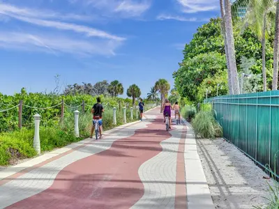 a group of people riding bikes down a path at Huge 2BD Miami beach with beach service - 720 in Miami Beach