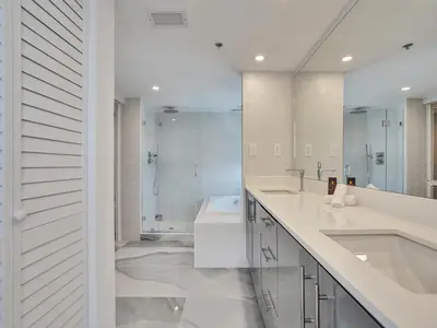 a white bathroom with two sinks and a bath tub at Luxury Oceanfront Condo Magnificent Views 701 in Miami Beach