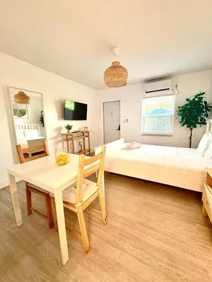 a bedroom with two beds and a table and a table and chair at Casa Agave Miami in Miami