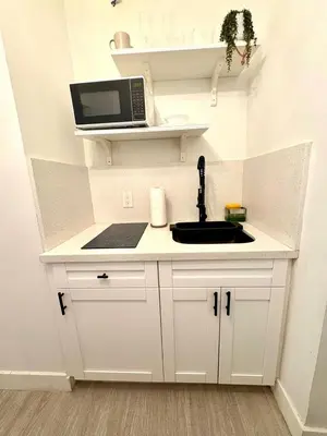 a kitchen with a sink and a laptop on a shelf at Casa Agave Miami in Miami