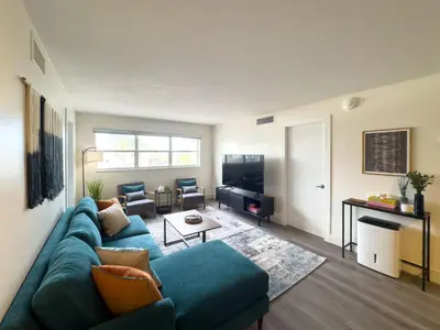 a living room with a blue couch and a tv at The Octagon in South Beach in Miami Beach