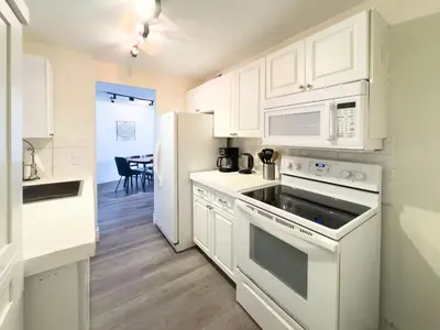 a kitchen with white cabinets and a white refrigerator at The Octagon in South Beach in Miami Beach