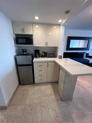 a kitchen with white cabinets and a counter top at Miami Beach Oceanfront in Miami Beach