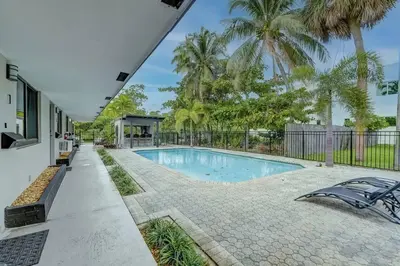 a swimming pool in a backyard with palm trees at Waterfront Deck Pool Kayak in Fort Lauderdale