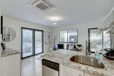 a kitchen with a sink and a living room at Waterfront Deck Pool Kayak in Fort Lauderdale