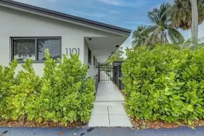 a white house with bushes in front of it at Waterfront Deck Pool Kayak in Fort Lauderdale