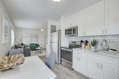 a kitchen with white cabinets and a table and a kitchen with a dining room at Pool Access Free Parking Smart TV Wifi in Fort Lauderdale