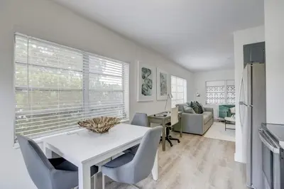a kitchen and living room with a white table and chairs at Pool Access Free Parking Smart TV Wifi in Fort Lauderdale