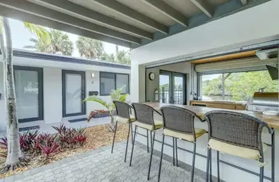 a kitchen with a bar with chairs and a table at Pool Access Free Parking Smart TV Wifi in Fort Lauderdale