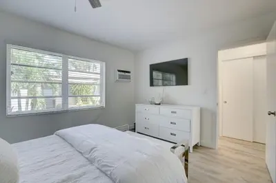 a white bedroom with a bed and a dresser and a window at Pool Free Wifi Parking Smart TV in Fort Lauderdale