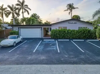 a house with a car parked in a parking lot at Pool Free Wifi Parking Smart TV in Fort Lauderdale