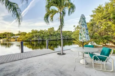 a patio with a table and chairs next to a body of water at Waterfront Apartment Private Patio Pool in Fort Lauderdale