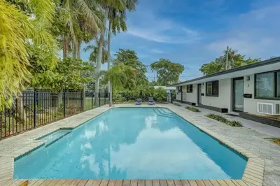 a swimming pool in the backyard of a house with palm trees at Waterfront Apartment Private Patio Pool in Fort Lauderdale