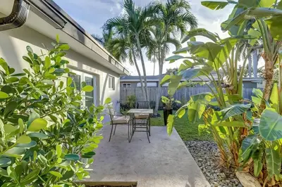 a patio with chairs and a table in a garden at Waterfront Apartment Private Patio Pool in Fort Lauderdale