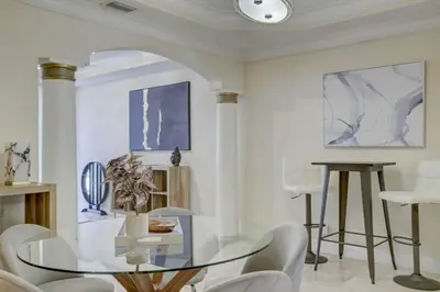 a dining room with a glass table and white chairs at Private Patio Cali King Bed Walk to Las Olas in Fort Lauderdale