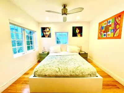 a bedroom with a bed and two windows at 12 GUESTS LUXURIOUS SOUTH BEACH SUITE 2 in Miami Beach