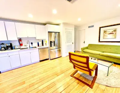 a kitchen and living room with a green couch at 12 GUESTS LUXURIOUS SOUTH BEACH SUITE 2 in Miami Beach