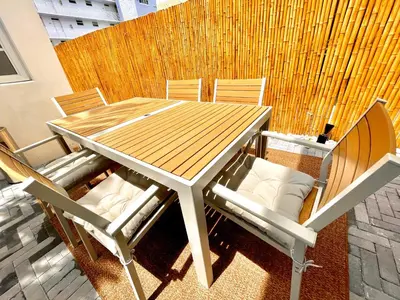 a wooden table and chairs on a patio at 12 GUESTS LUXURIOUS SOUTH BEACH SUITE 2 in Miami Beach